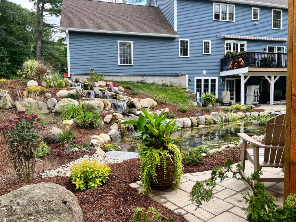 Koi pond with cascading waterfalls, established garden and patio